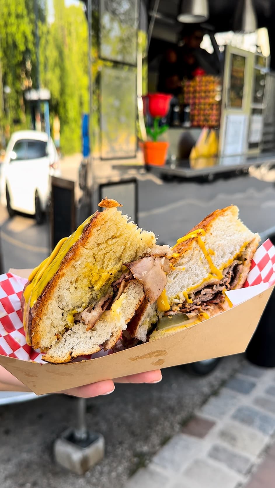 Aufgeschnittenes Cubano Sandwich im Pappschälchen vor dem Foodtruck