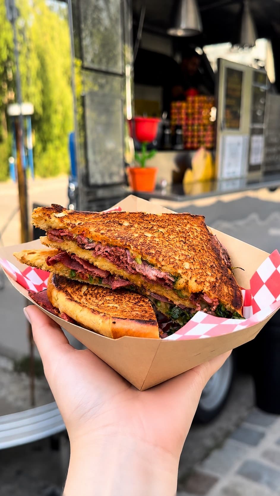 Pastrami Sandwich im Pappschälchen vor dem Foodtruck